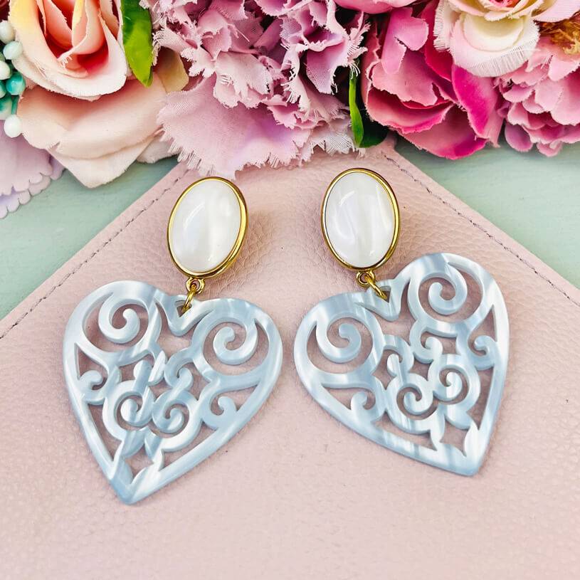 SchwesterSchwester Schöne Herz-Ohrringe mit perlmuttfarbenen Ohrsteckern und Herz-Ornamenten in hellblau von AmuseToi