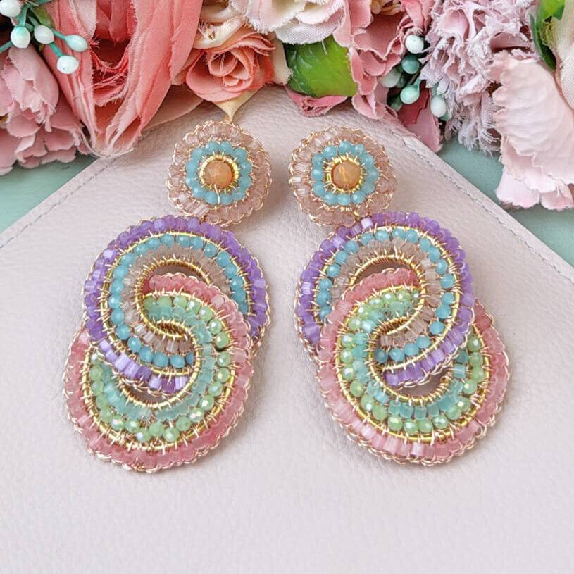 SchwesterSchwester Vergoldete Ohrstecker mit verschlungenen Ringen aus vielen pastellfarbenen Perlen